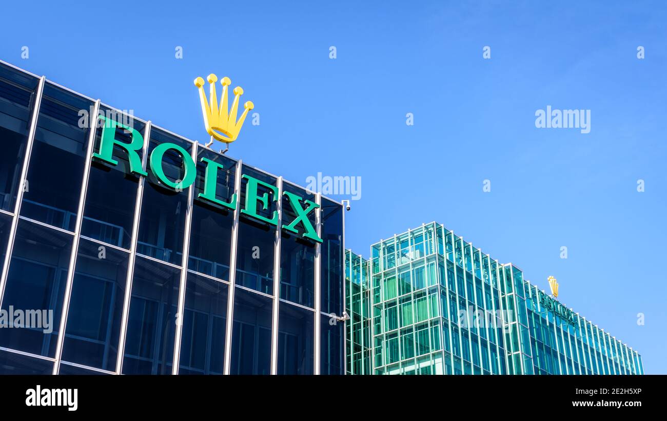 Low angle view of the Rolex logo at the top of a building at the headquarters of the swiss brand of luxury watches in Geneva. Stock Photo