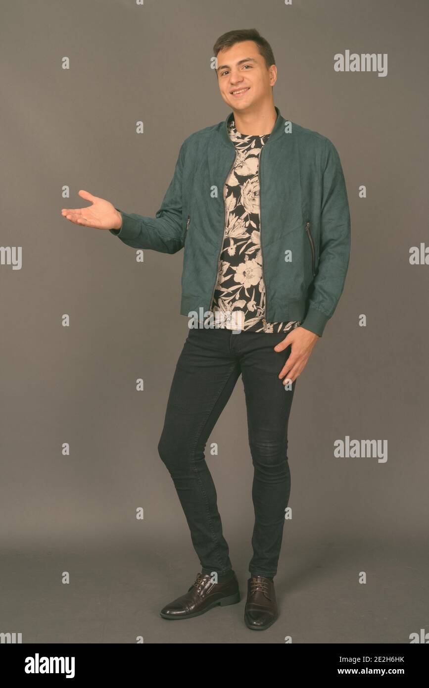 Studio shot of young handsome man against gray background Stock Photo ...