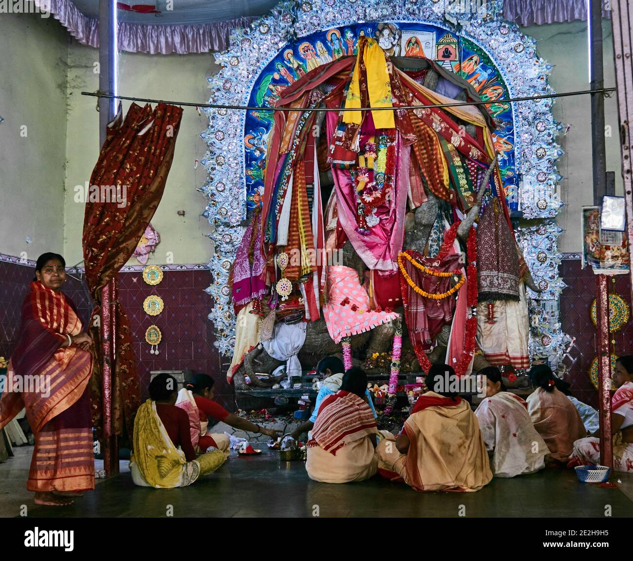 Kalna City, West Bengal, India. The faithful place offerings before alta to Durga, the Hindu deity in Kalna. The statue is covered with colored fabric Stock Photo