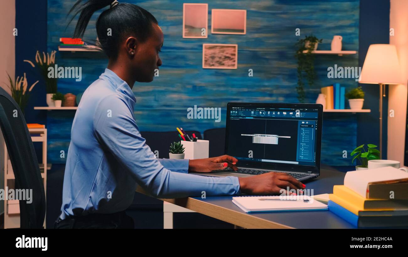 African american remote woman architect working on modern cad program overtime. Industrial black female engineer studying prototype idea on personal computer showing software on device display Stock Photo