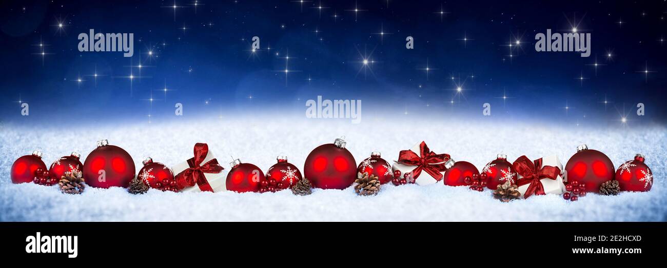 red silver christmas decoration ornament bauble gift boxes with ribbon and bright lights in front of blue stars bokeh wide panorama background Stock Photo