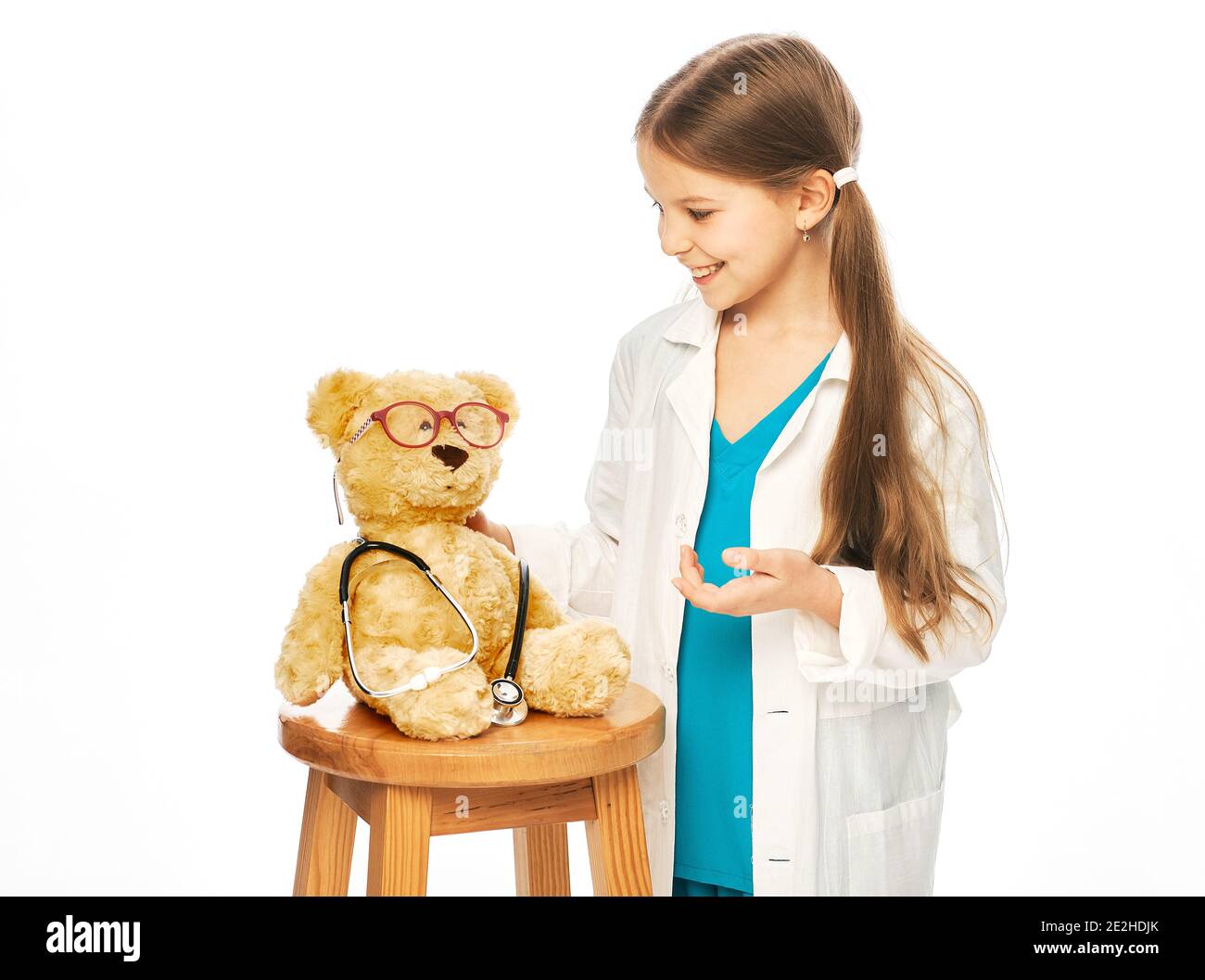 Cute girl playing in doctor profession with a bear toy. Child's hobby and future medical occupation Stock Photo