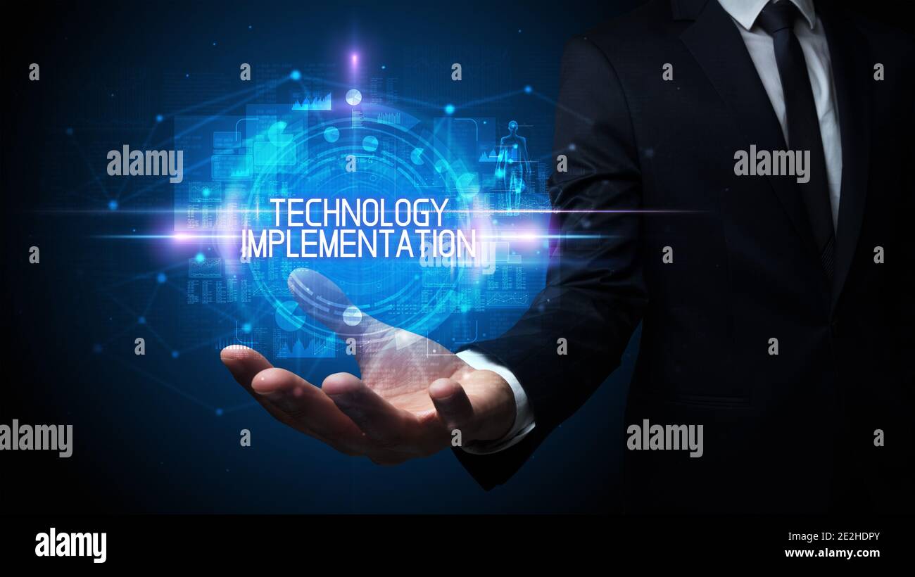 Man hand holding TECHNOLOGY IMPLEMENTATION inscription, technology concept Stock Photo