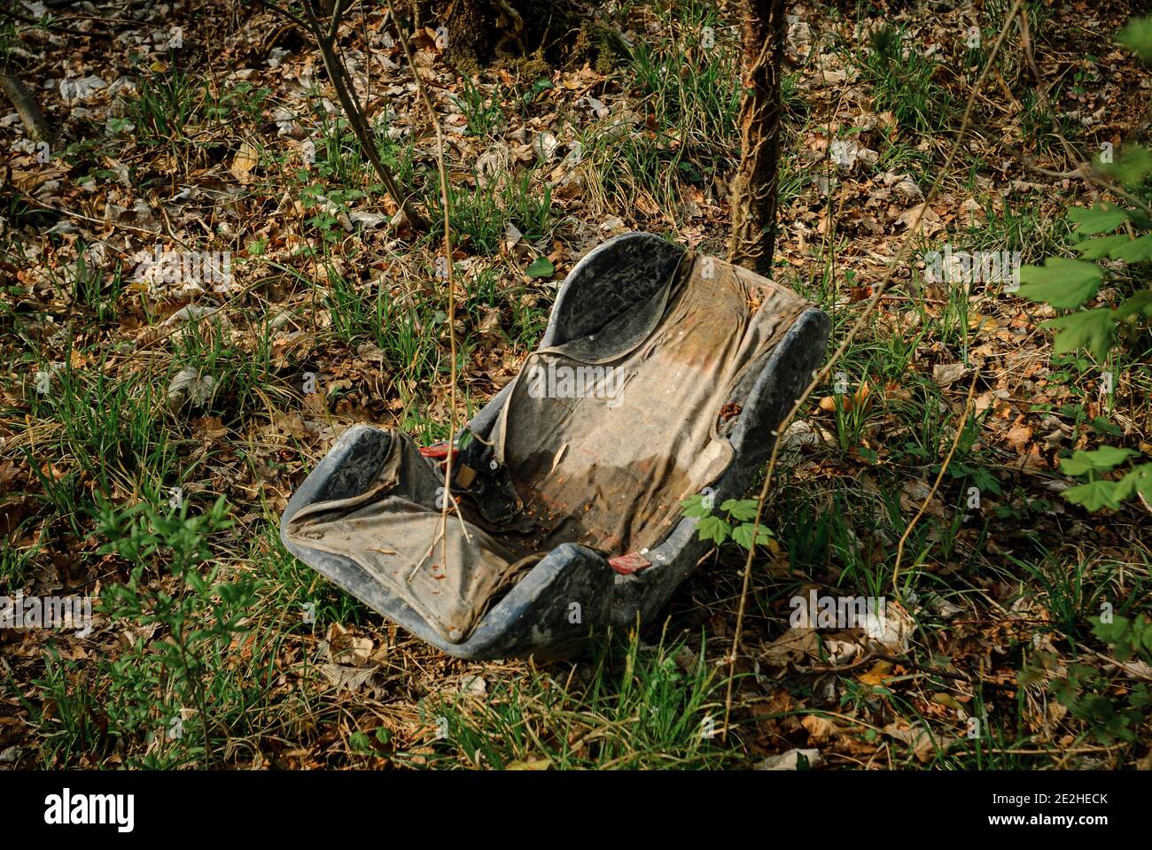 Abandoned baby seat in the forest near Strasbourg, France. A car seat growing old alone in a wood near Strasbourg France. Stock Photo