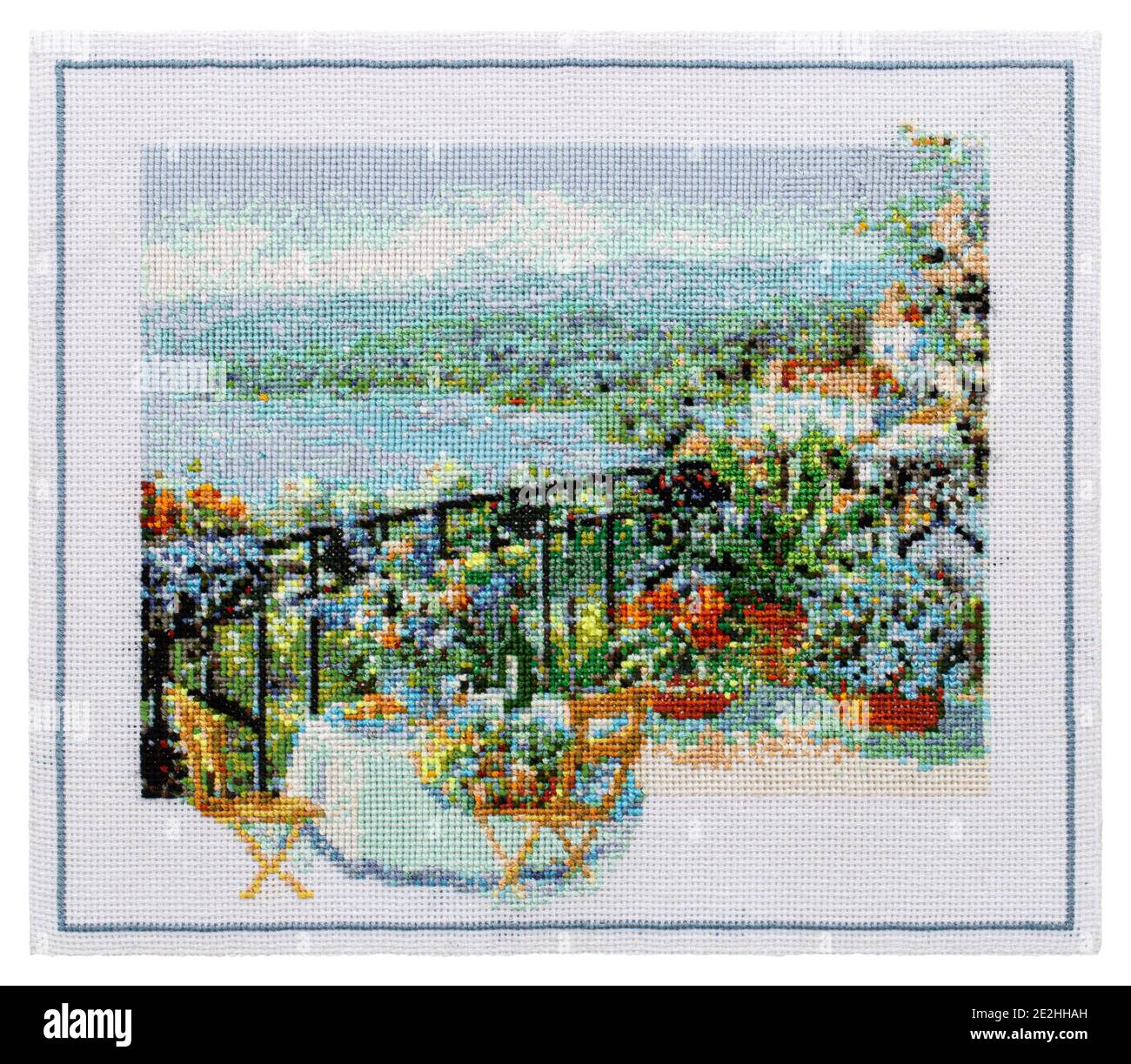 Embroidered picture, outdoor cafe terrace overlooking the sea, cross-stitch on textile canvas, isolated on white background Stock Photo