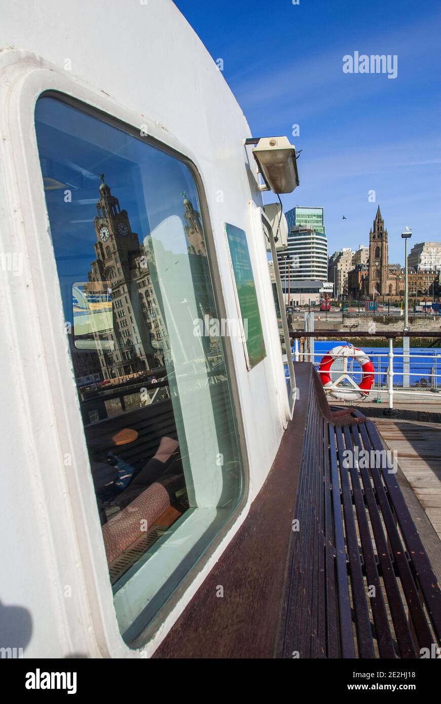 A Mersey ferry pictured berthed at the Liverpool Pier Head with the Parish church of St. Nicholas and the Royal Liver building in the background. Stock Photo