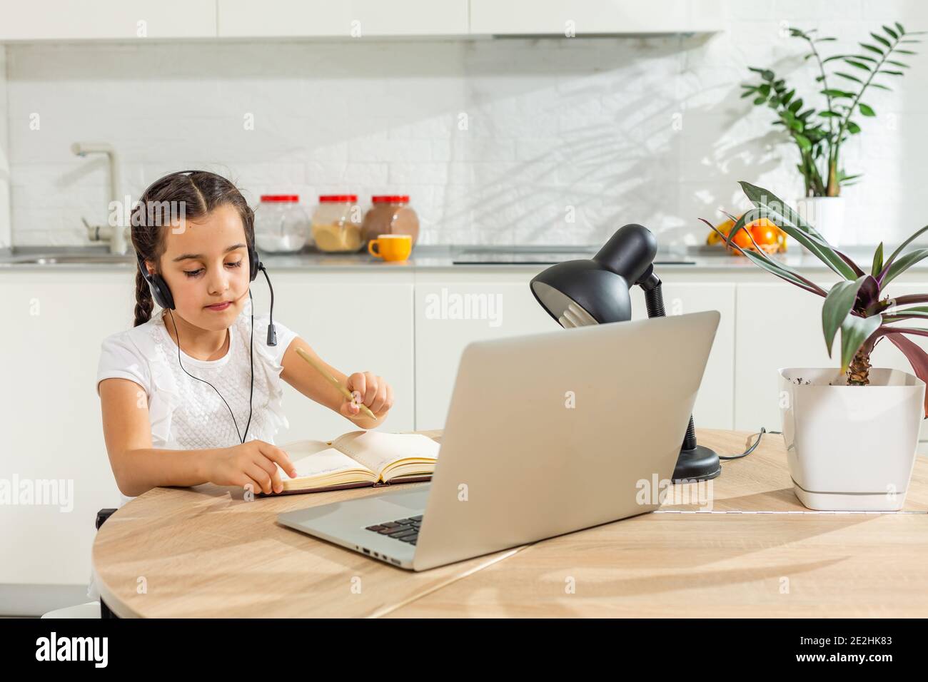 Kids distance learning. Cute little girl using laptop at home ...