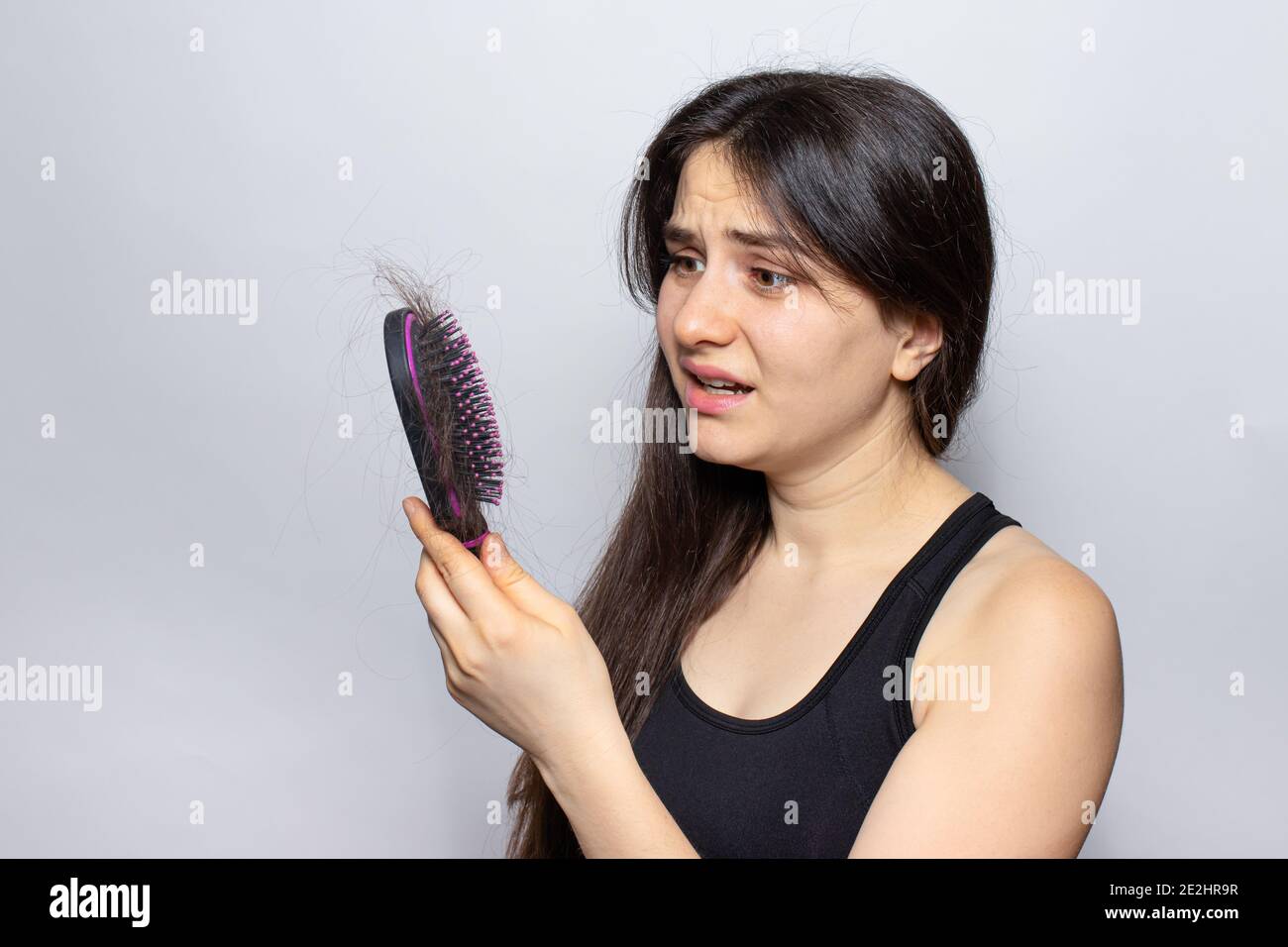 The girl holds a comb for hair with fallen hair. Hair loss, hair care Stock Photo