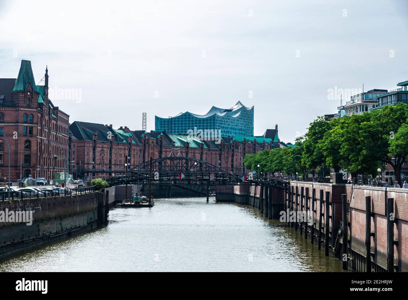 Hamburg, Germany - August 23, 2019: Old warehouses converted into offices and flats next to a canal and the Elbphilharmonie, Elbe Philharmonic Hall, w Stock Photo