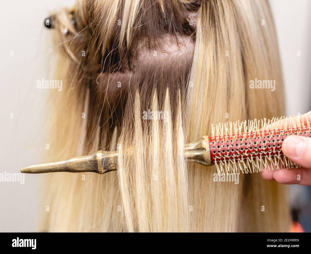 Hair extensions correction procedure. Hairdresser does hair extensions