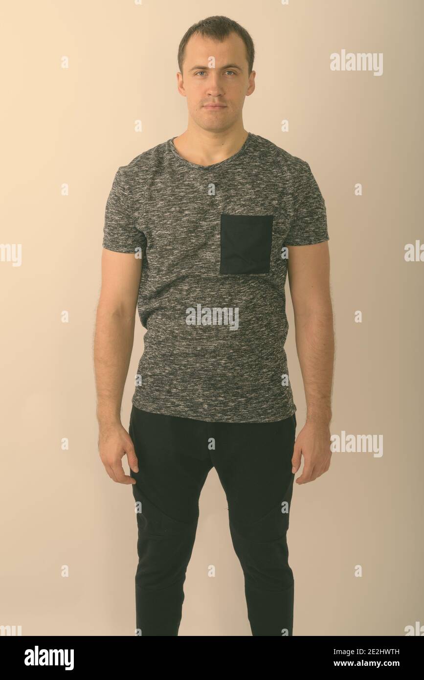 Studio shot of young muscular man standing against white background ...