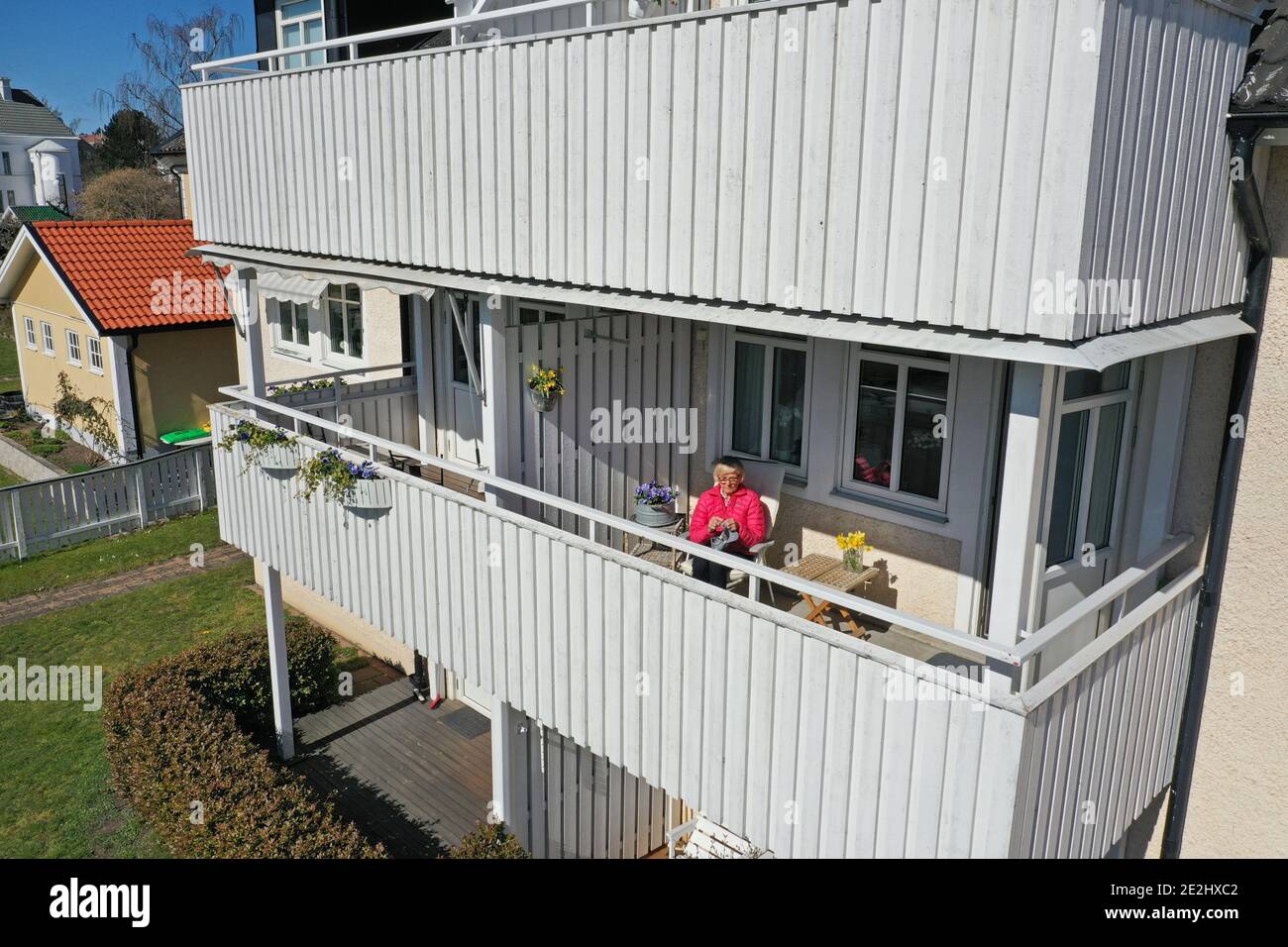 MOTALA, SWEDEN- 16 APRIL 2020: Balcony life during the corona crisis. Gunvor lives isolated like everyone over 70 years in quarantine, here photographed on the balcony, during the corona crisis. Stock Photo