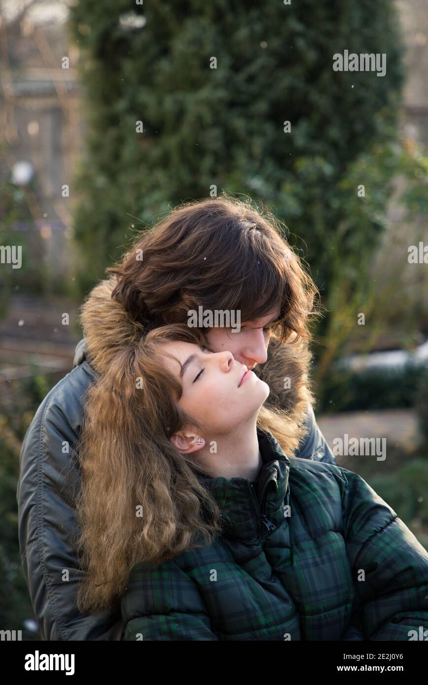 enamored young guy and teenage girl hug, enjoy the moment. Outdoors during the cold season of the year. Joyful meeting, tender feelings. Valentine's D Stock Photo