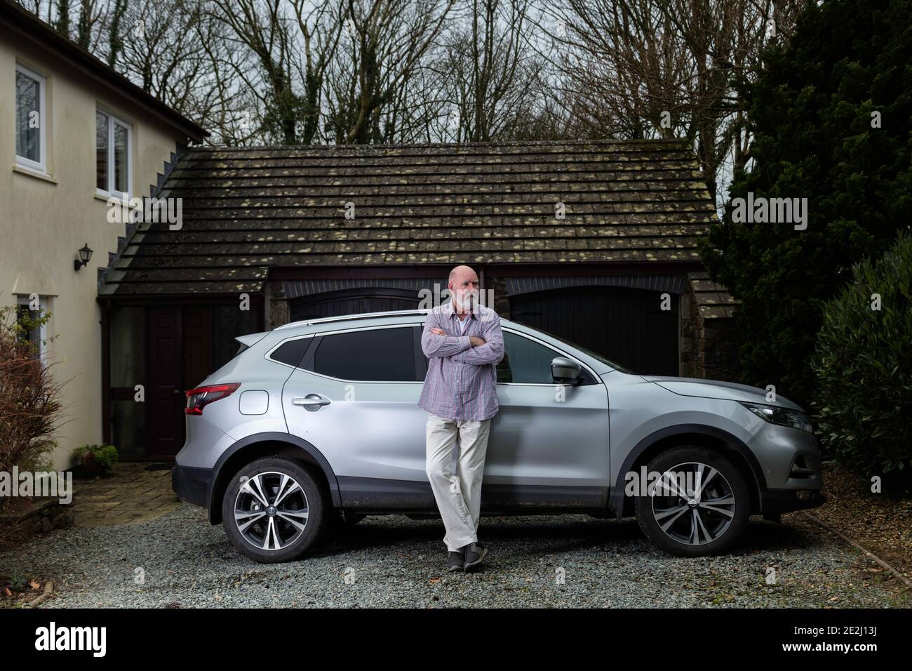 Casually dressed senior man with his silver car. Stock Photo