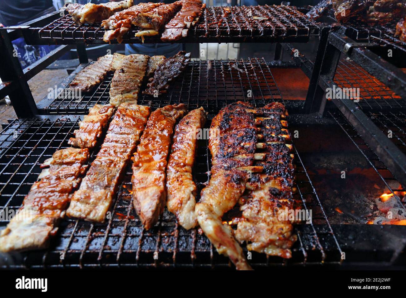 Meatopia in Tobacco Dock in London.Iberico pork ribs grilling on barbecue grill . Stock Photo