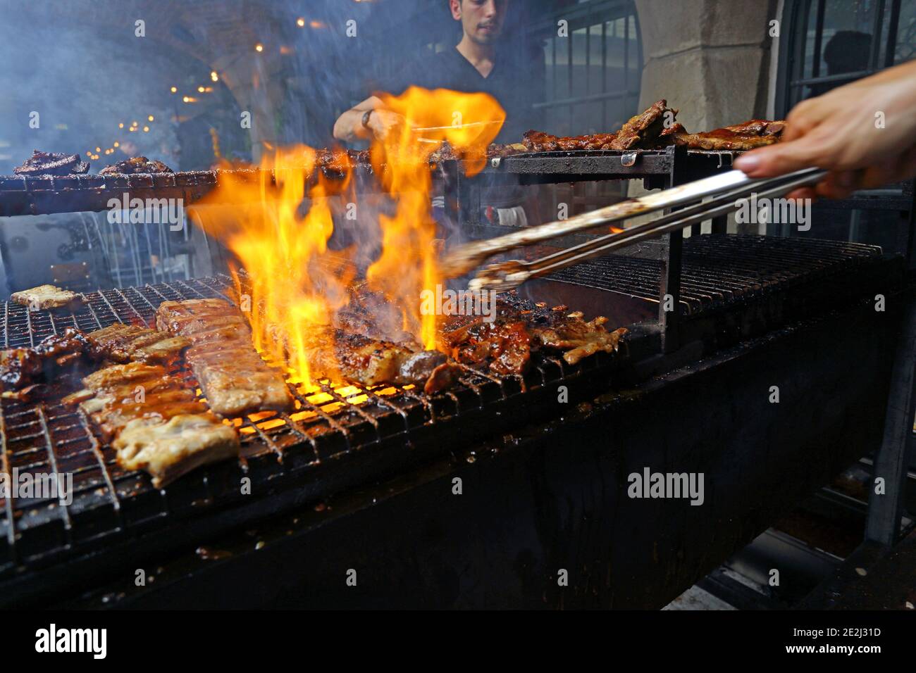 Meatopia in Tobacco Dock in London.chef grilling on barbecue grill Stock  Photo
