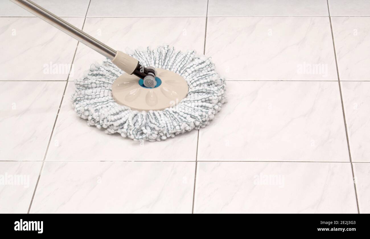 Cleaning mop on white ceramic tile floor background Stock Photo - Alamy