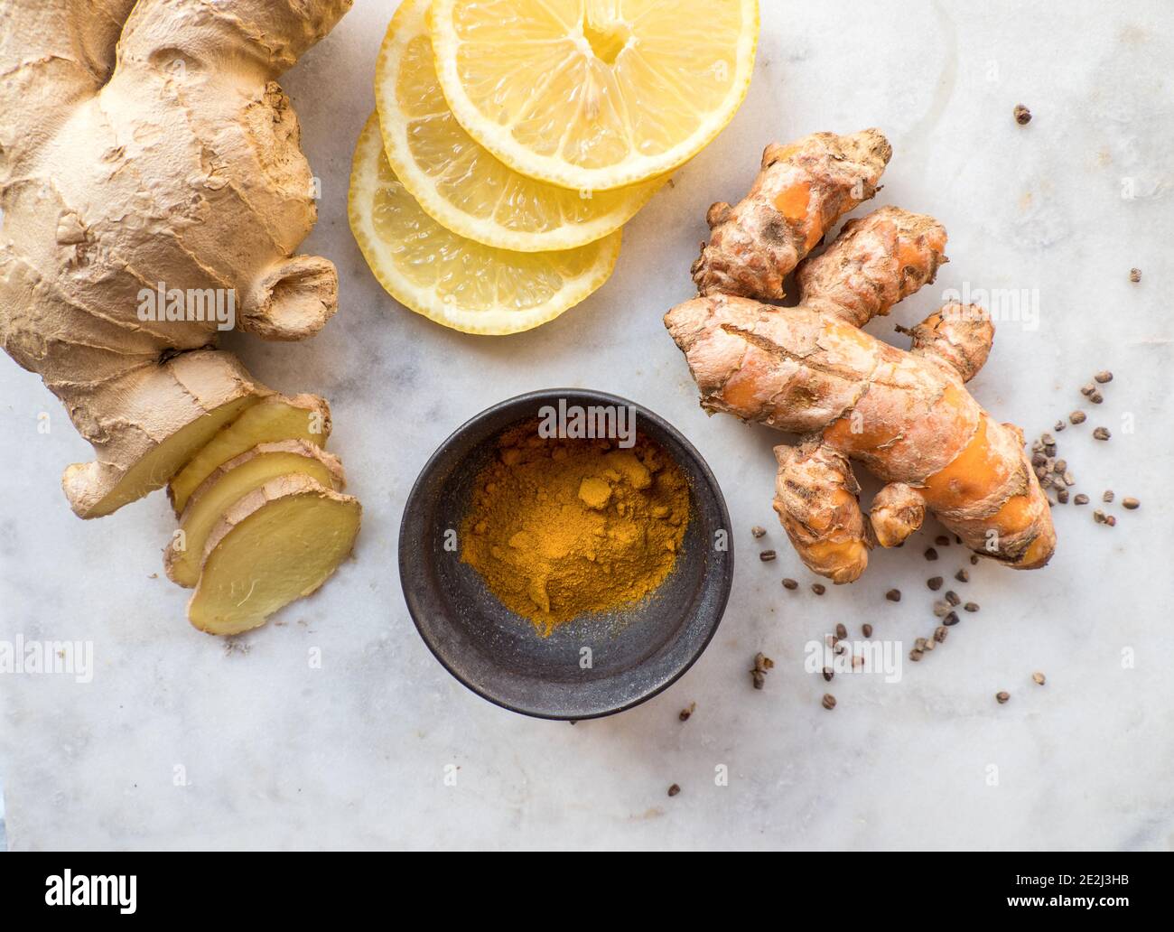 Naturally healthy and immune system boosting Turmeric spice powder, lemon slices and ginger roots Stock Photo