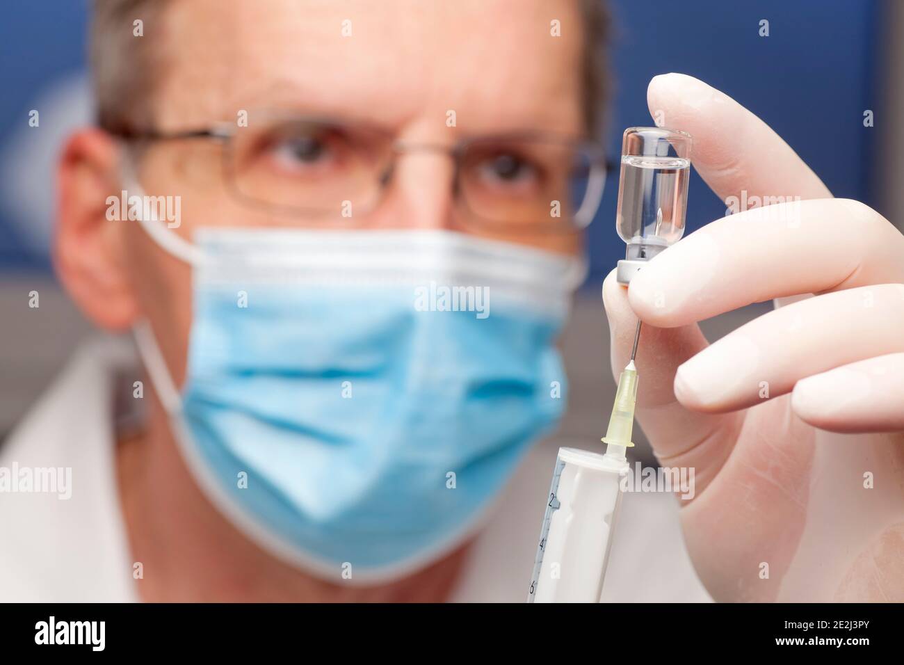 Close-up of doctor preparing a syringe for vaccination against covid-19 - focus on the syringe Stock Photo