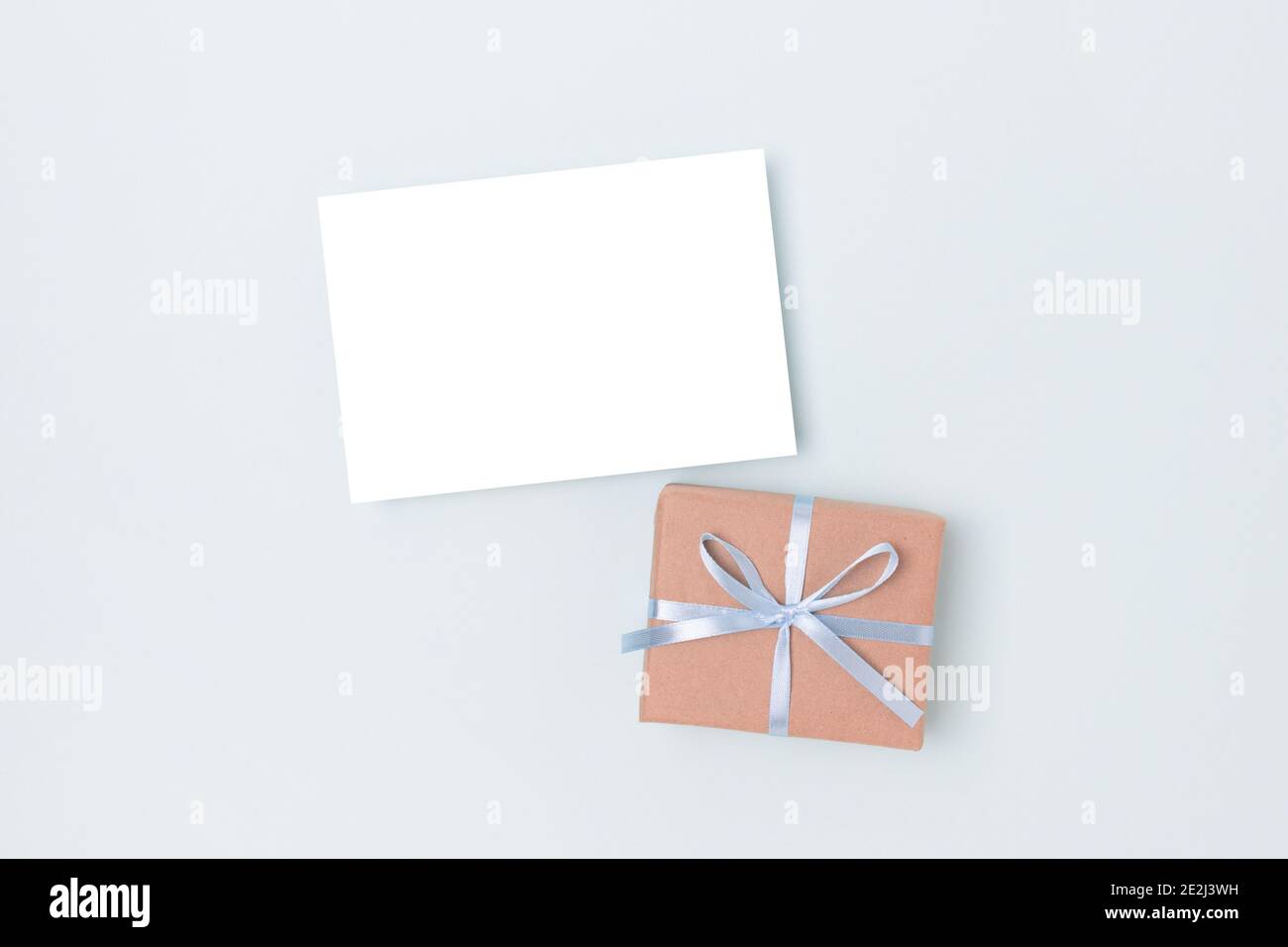 Download Paper Sheet Mockup And Present Tied With A Ribbon On A Blue Background Gift Box And Greeting Card Template Stock Photo Alamy