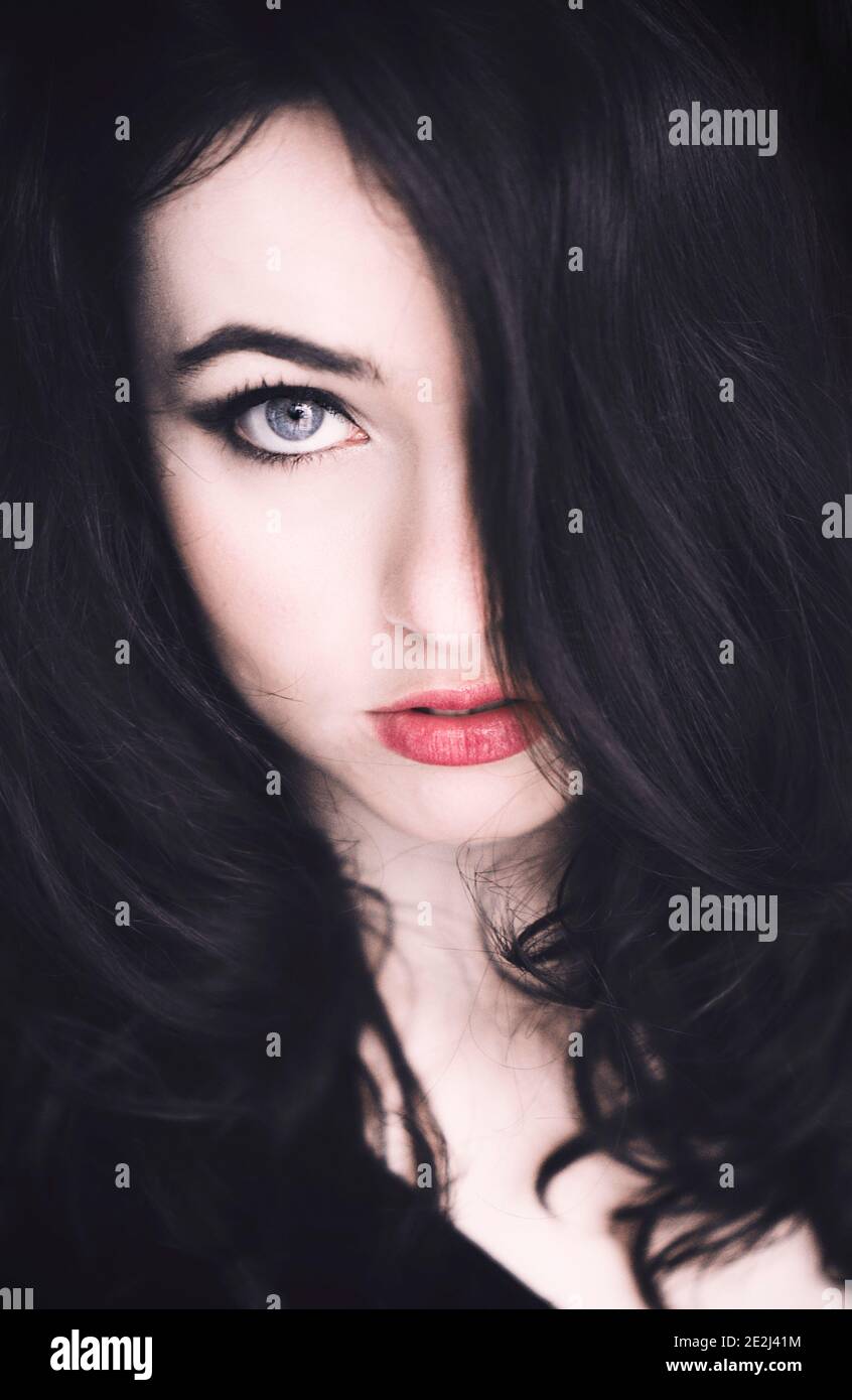 Portrait of a beautiful young woman with hair covering half of her face Stock Photo