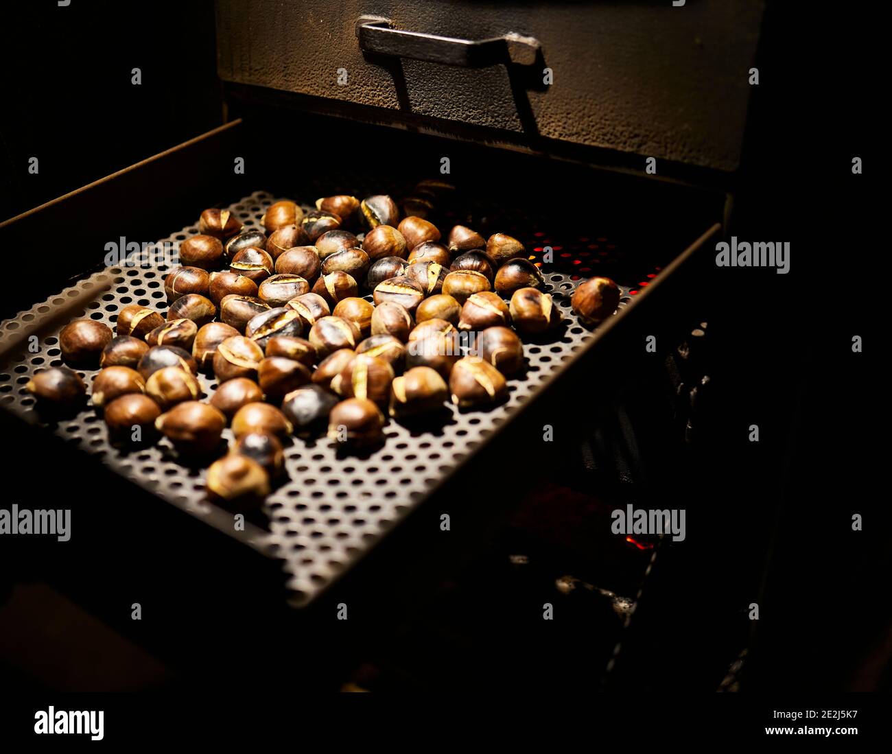 Roasting chestnuts in a woodfired oven Stock Photo Alamy