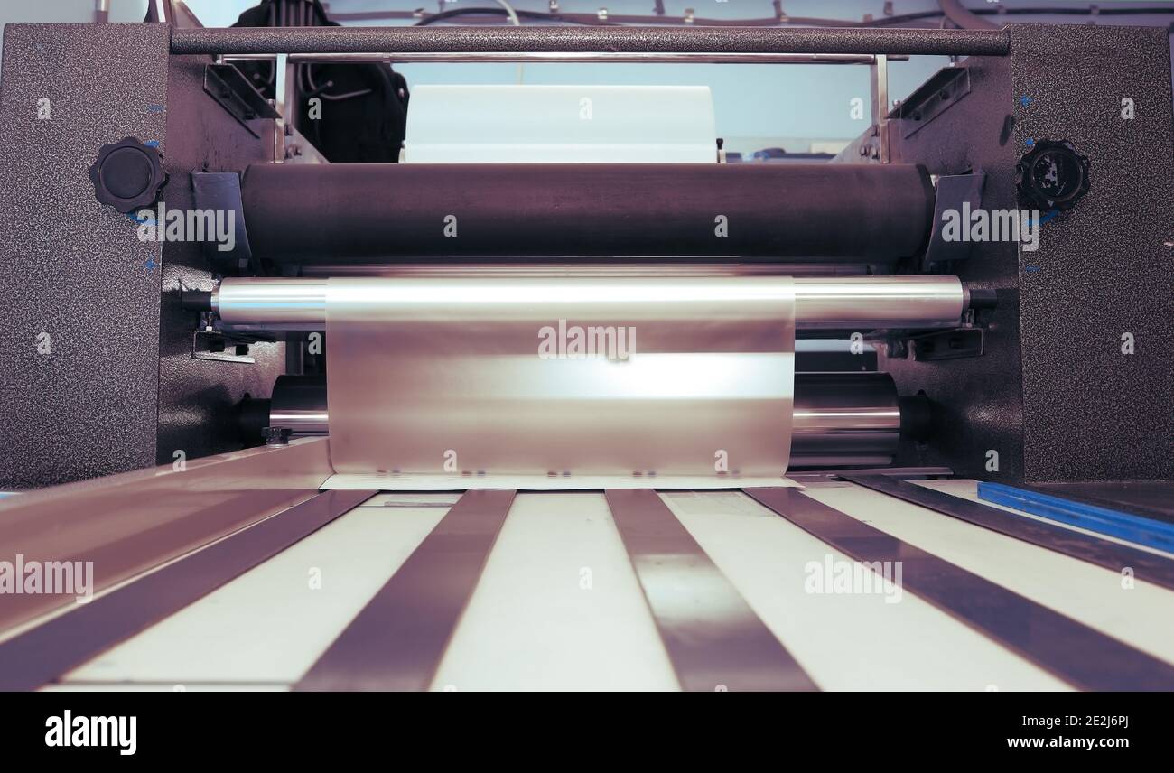 Laminating machine in print shop. Stock Photo