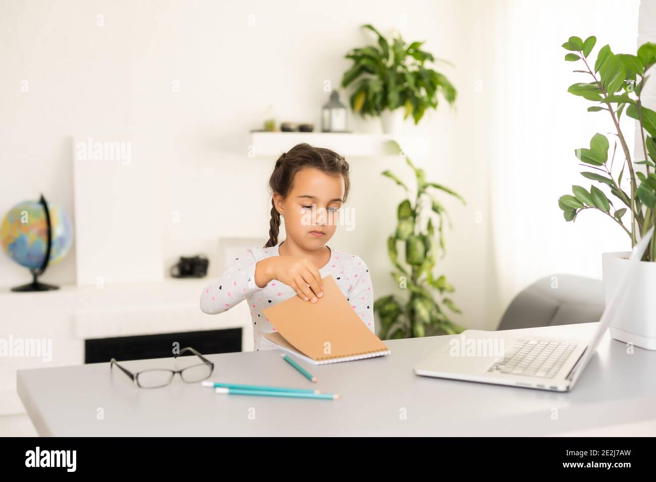 Little girl studying online using her laptop at home Stock Photo - Alamy