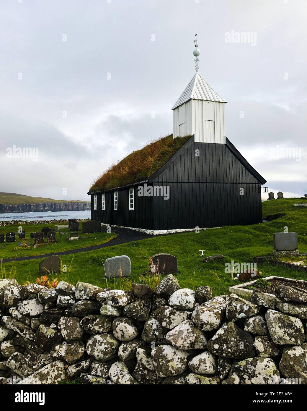 Sandoy, Faroe Islands: Black wooden church of Sandur with grass roof, that was renovated after an arson. Stock Photo
