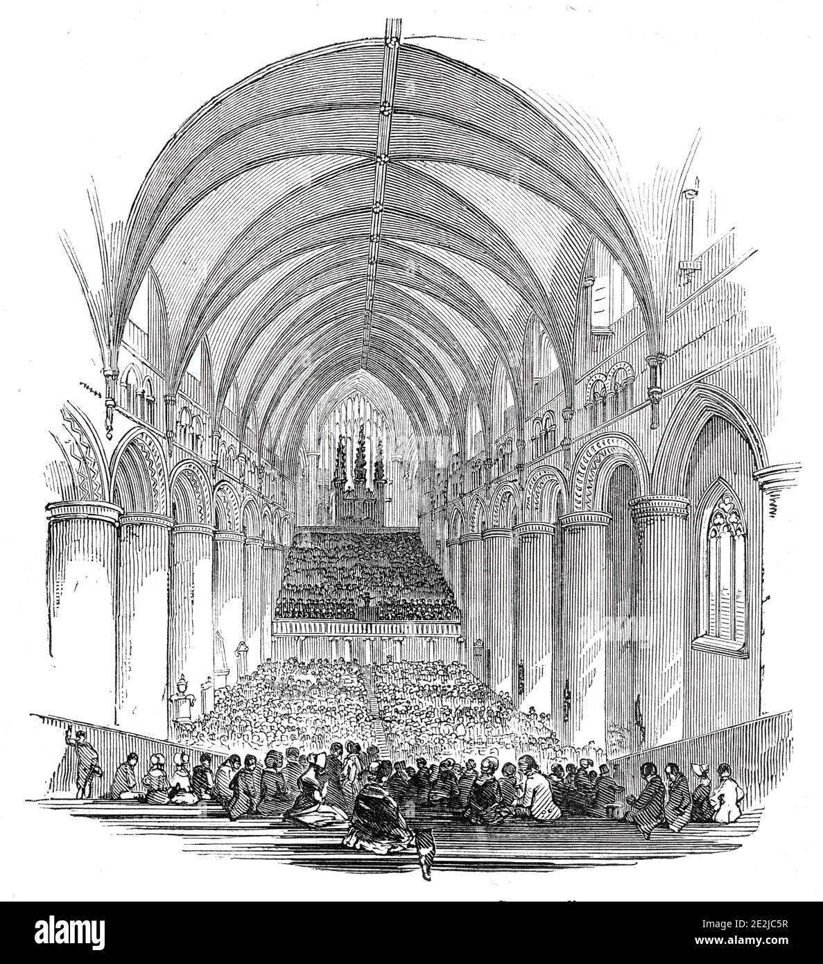 The Gloucester Musical Festival, 1844. '...the hundred and fifty-first annual meeting of the three choirs of Hereford, Gloucester, and Worcester, for the benefit of the Widows and Orphans' Fund of the clergy connected with the three dioceses was commenced in the antique Cathedral of Gloucester...The performance opened with full cathedral service. The whole of the spacious nave of the western part of this noble edifice was fitted up with great care and neatness. Immediately in front of the organ were fixed the seats for the orchestral performers, three hundred in number...'. From &quot;Illustra Stock Photo