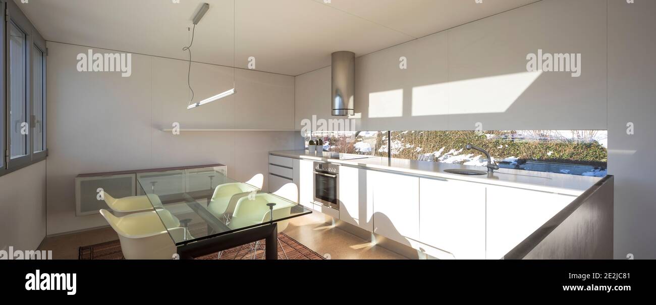 luxurious kitchen with dining table and four chairs inside Stock Photo