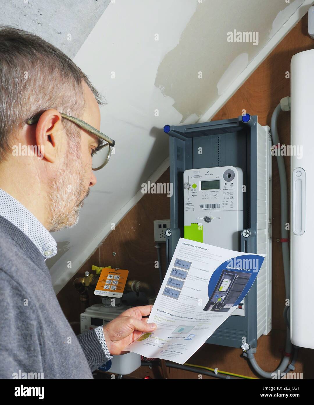 Illustration picture shows a man inspecting his Sagemcom smart electricity  meter in Gent, on Thursday 14 January 2021. BELGA PHOTO CHLOE FRANCOIS  Stock Photo - Alamy