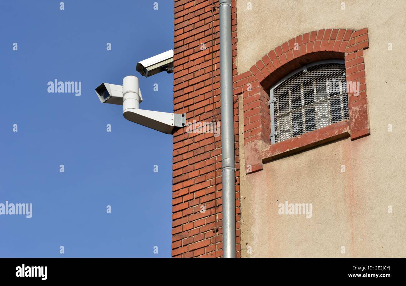 Prison window and cctv surveillance cameras on the corner Stock Photo