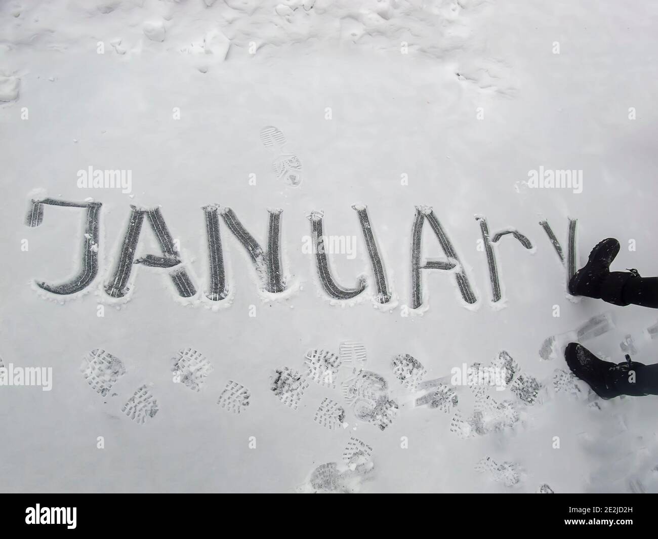 the word january girl wrote in the snow with her boot Stock Photo