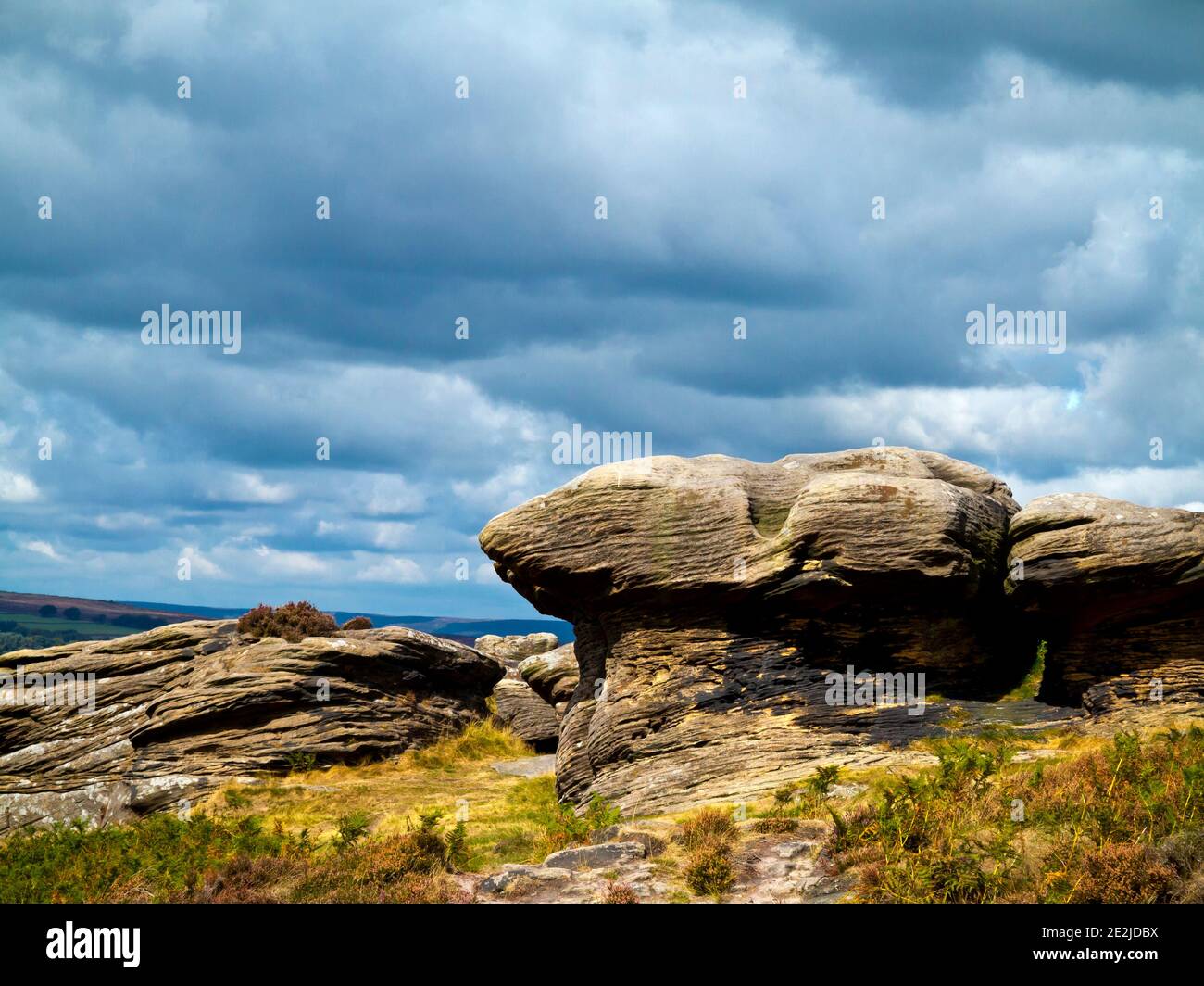 Storm clouds above the rock formations at Curbar Edge in the Peak District National Park Derbyshire England UK Stock Photo