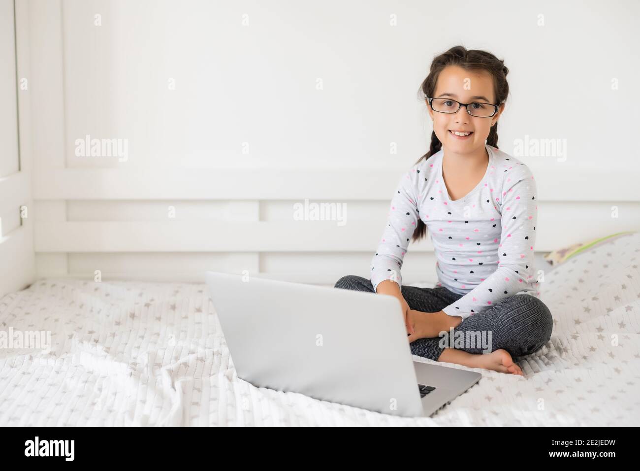 Little girl studying online using her laptop at home Stock Photo - Alamy