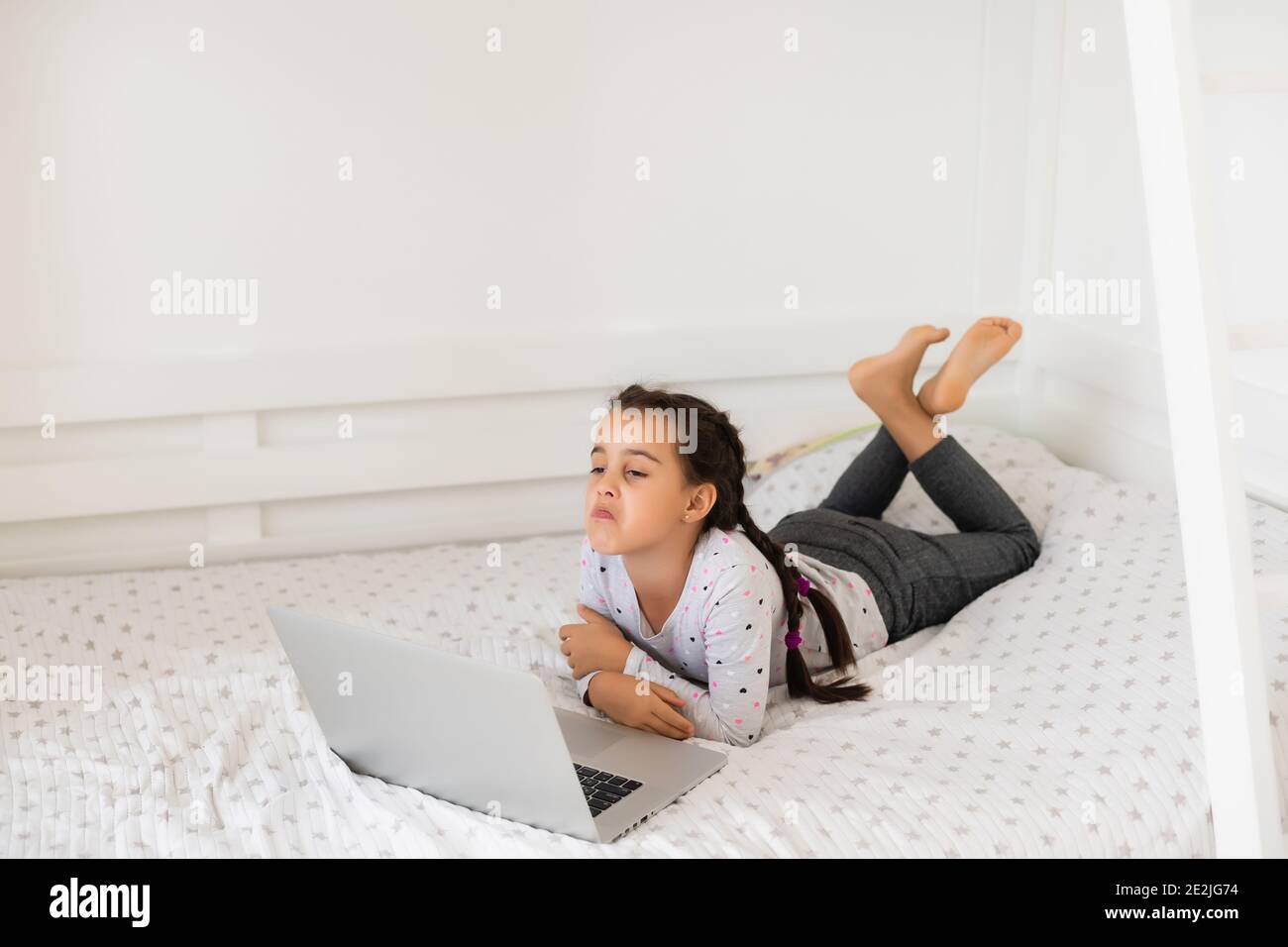 Little girl studying online using her laptop at home Stock Photo - Alamy