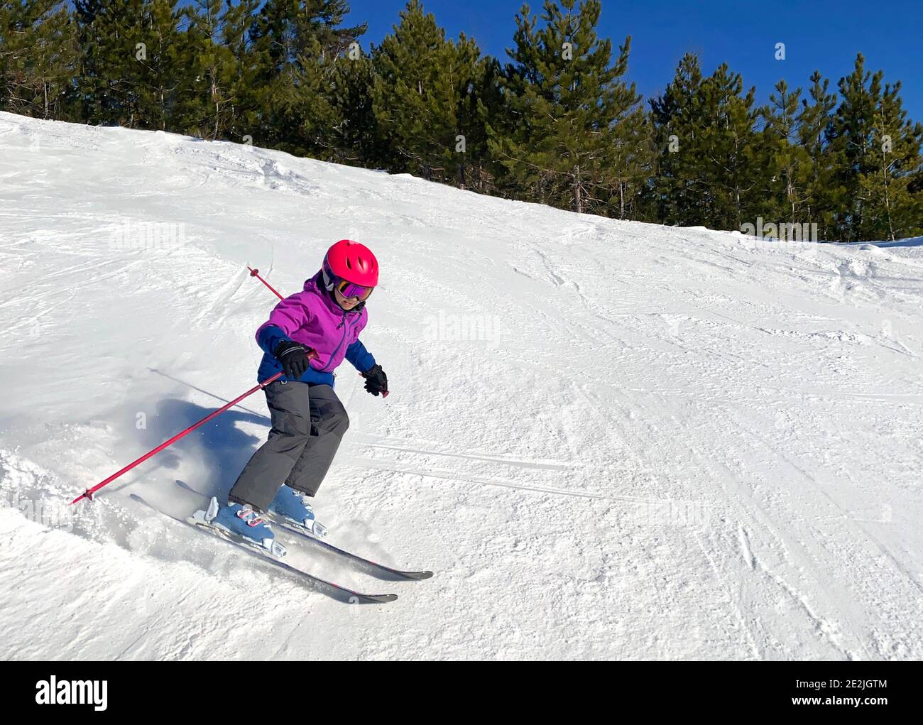 Young girl downhill skiing on an open slope at a ski resort in Quebec, Canada Stock Photo