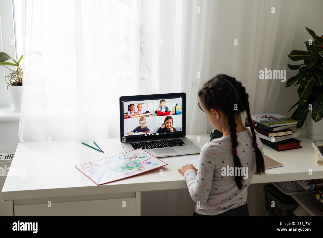 Little girl studying online using her laptop at home Stock Photo - Alamy