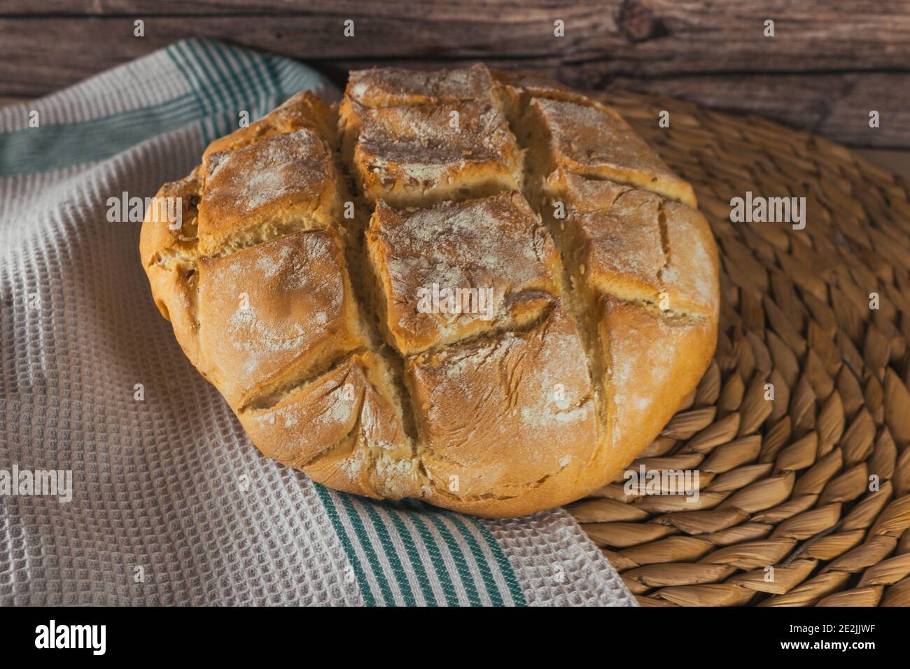 Homemade rustic bread loaf made with wheat flour on a dark background ...