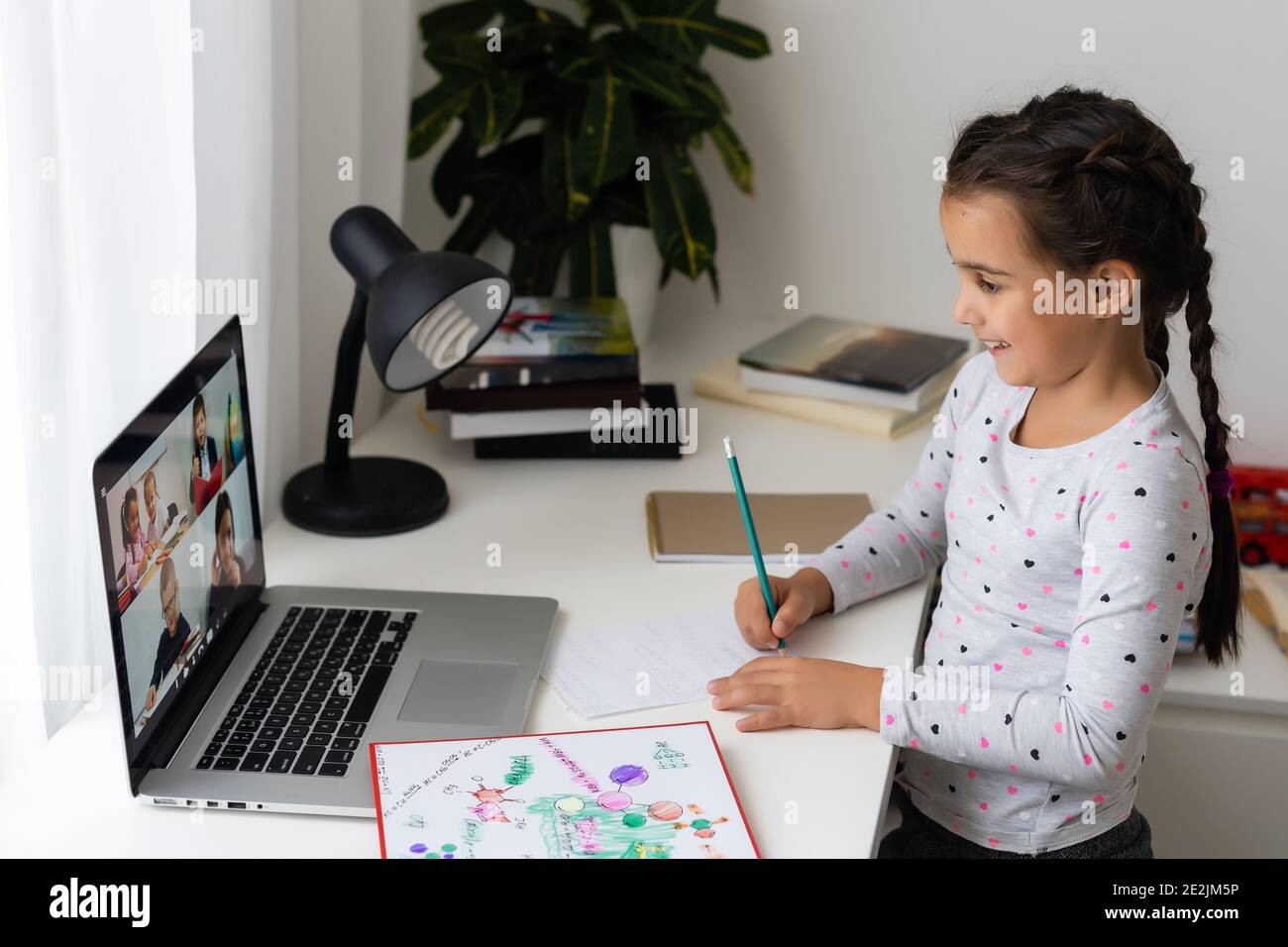 Little girl studying online using her laptop at home Stock Photo - Alamy