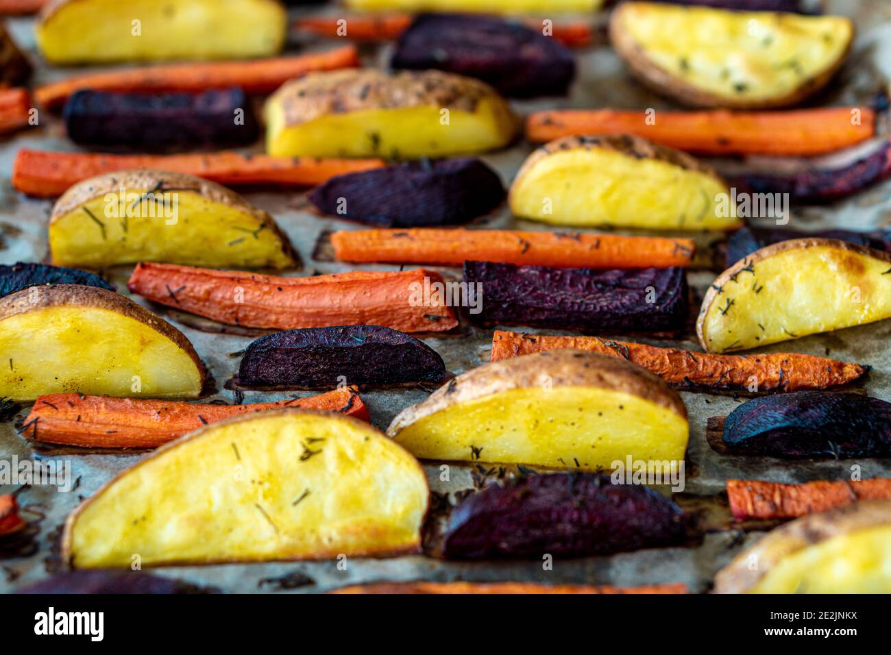 restaurant, vegetarianism, fast, healthy food, recipes concepts - Oven baked cut vegetables potatoes carrots, beets with seasoning dill. Roasted Stock Photo