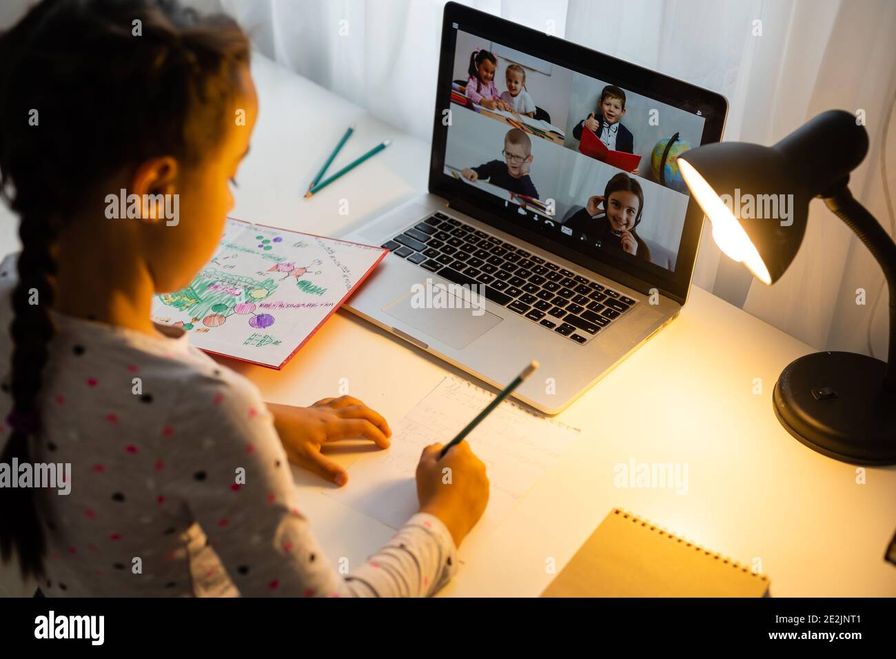 Little girl studying online using her laptop at home Stock Photo - Alamy