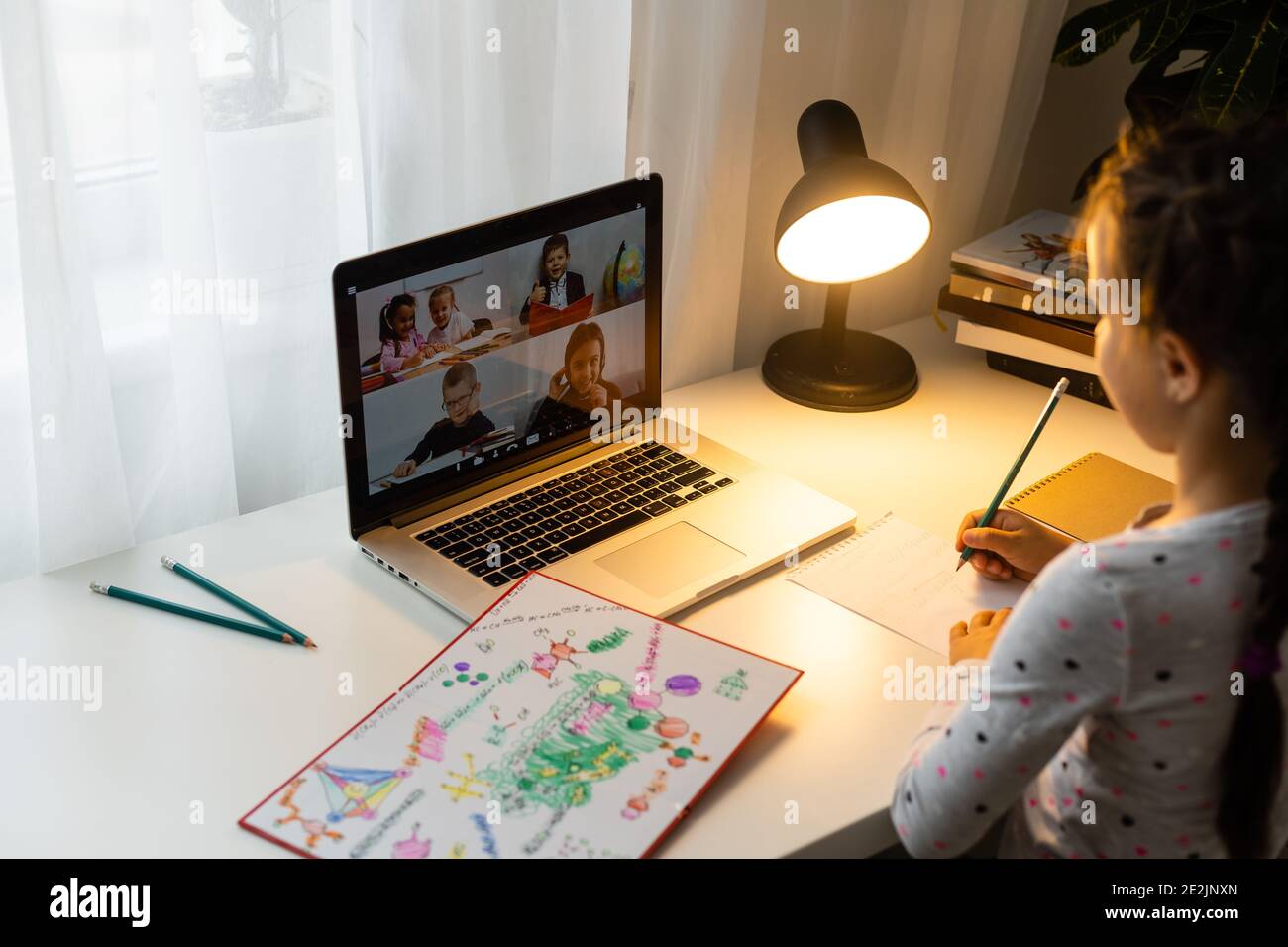 Little girl studying online using her laptop at home Stock Photo - Alamy