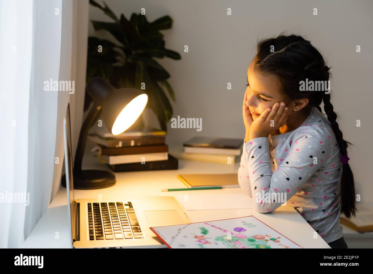 Little girl studying online using her laptop at home Stock Photo - Alamy