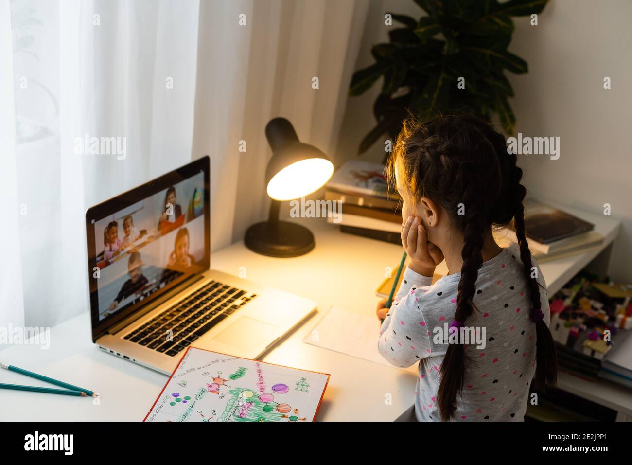 Little girl studying online using her laptop at home Stock Photo - Alamy
