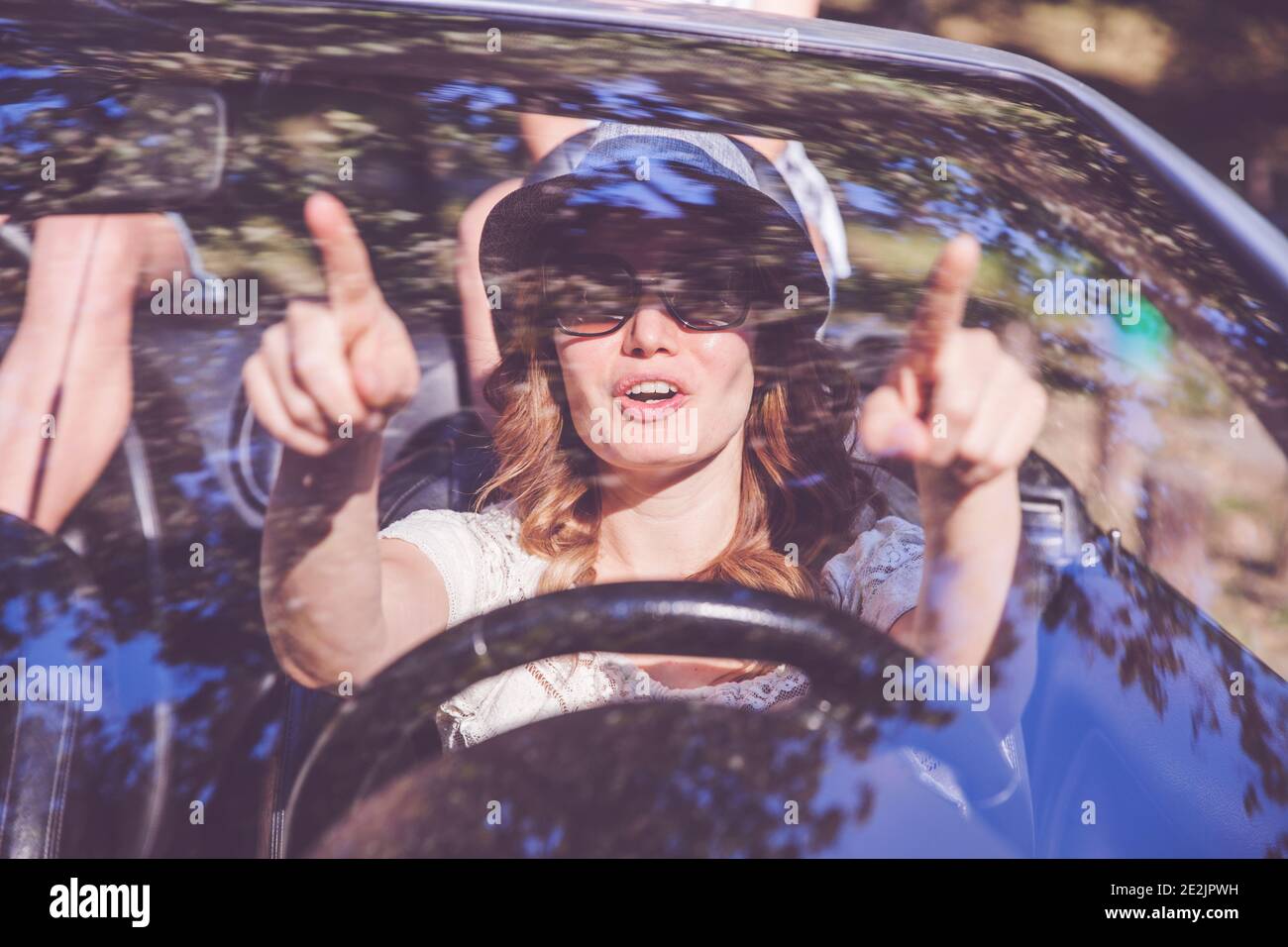 Beautiful woman with sunglasses driving car, looking through windshield with reflection Stock Photo