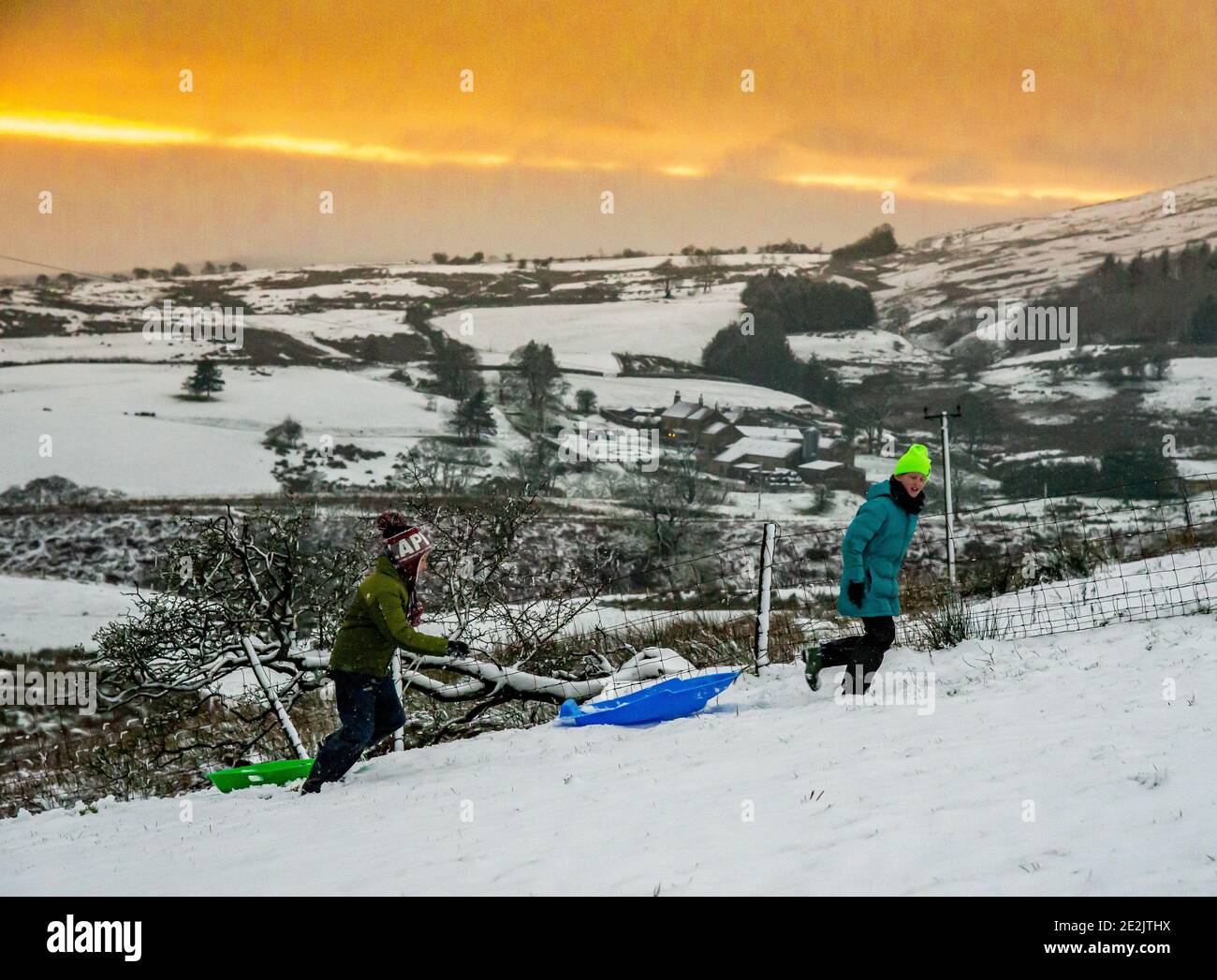 Preston, Lancashire, UK. 14th Jan, 2021. Sledging in the snow at sunset in the fells near Preston, Lancashire. Credit: John Eveson/Alamy Live News Stock Photo