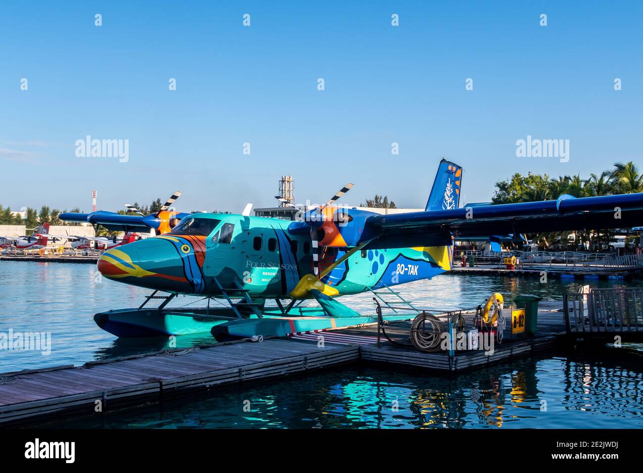 Male, Maldives, 20.11.2020. Trans Maldivian Airways colorful seaplane Twin Otter Series 400 docked at seaplane terminal, Four Seasons Resort painting. Stock Photo