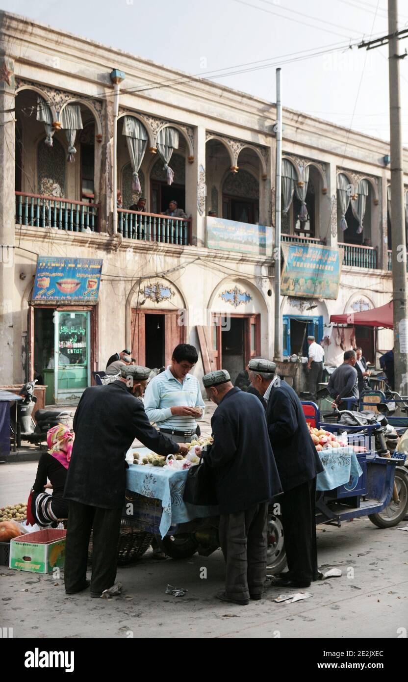 Street vendor and the old Uyghur tea house in Kashgar's old town,  Xinjiang Province, China.  5th Oct. 2011. Photograph: Stuart Boulton. Stock Photo